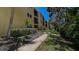 A condo building view with a sidewalk and mature foliage at 11485 Oakhurst Rd # 310, Largo, FL 33771