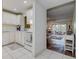 Bright kitchen featuring white cabinets, tile floor, and a view into the living area at 11485 Oakhurst Rd # 310, Largo, FL 33771