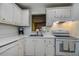Bright kitchen featuring white appliances and cabinets, gold hardware, and a stainless steel sink at 11485 Oakhurst Rd # 310, Largo, FL 33771