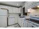 This kitchen features white cabinets, countertop, and appliances at 11485 Oakhurst Rd # 310, Largo, FL 33771