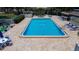 Community outdoor pool with brick paver surround and lounge chairs next to well-maintained landscaping at 11485 Oakhurst Rd # 310, Largo, FL 33771