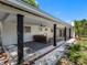 Outdoor seating area in the backyard, featuring a covered patio, ceiling fans, and views of the green space at 1154 64Th S Ave, St Petersburg, FL 33705