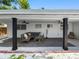 Inviting covered porch with comfortable seating, ceiling fans, and a view of the landscaped backyard at 1154 64Th S Ave, St Petersburg, FL 33705