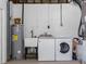 Functional basement laundry area featuring a washing machine, dryer, utility sink, and water heater at 1154 64Th S Ave, St Petersburg, FL 33705