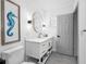 Bright bathroom features a modern vanity, a round mirror, and a toilet at 1154 64Th S Ave, St Petersburg, FL 33705