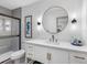 Updated bathroom features a white vanity with a round mirror and a glass-enclosed shower at 1154 64Th S Ave, St Petersburg, FL 33705