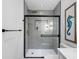 Updated bathroom showcasing a gray tiled shower with gold fixtures and sleek glass door at 1154 64Th S Ave, St Petersburg, FL 33705