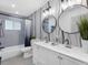 Modern bathroom featuring double sink vanity, subway tile shower, and decorative wallpaper at 1154 64Th S Ave, St Petersburg, FL 33705