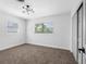 Bright bedroom with neutral carpet, updated lighting, and a view to the exterior at 1154 64Th S Ave, St Petersburg, FL 33705