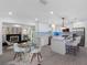 Open kitchen with island seating, stainless appliances, white cabinets, and stylish lighting at 1154 64Th S Ave, St Petersburg, FL 33705