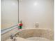 Close up view of beige marble bathtub with wall-mounted faucet, surrounded by white tiles at 1222 Rainbrook Cir, Valrico, FL 33596