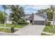 Inviting home featuring a well-maintained lawn, mature trees, and a convenient attached two-car garage at 1222 Rainbrook Cir, Valrico, FL 33596