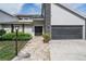 Welcoming entrance with brick accents, a dark garage door, and a paved walkway at 1222 Rainbrook Cir, Valrico, FL 33596