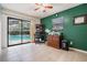 Bright office with a green accent wall, ceiling fan, and view of the pool outside at 1222 Rainbrook Cir, Valrico, FL 33596