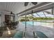Screened-in pool area with lounge chairs, dining set, hot tub and a beautiful lake view at 1222 Rainbrook Cir, Valrico, FL 33596