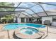 A sparkling pool and hot tub await in this screened-in outdoor oasis at 1222 Rainbrook Cir, Valrico, FL 33596