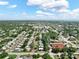 Expansive aerial view of a neighborhood with lush greenery and a clear blue sky dotted with fluffy white clouds at 12316 Eldon Dr, Largo, FL 33774