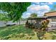 Backyard featuring a screened-in porch, lawn, mature foliage, and a white privacy fence at 12316 Eldon Dr, Largo, FL 33774