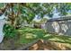 Large grassy backyard with a storage shed, an enclosed back porch, and mature trees at 12316 Eldon Dr, Largo, FL 33774