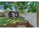 Backyard featuring a grassy area, storage shed, garden bed, and a white vinyl fence at 12316 Eldon Dr, Largo, FL 33774