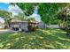 View of backyard featuring a lawn, screened-in porch, and a small storage shed at 12316 Eldon Dr, Largo, FL 33774