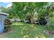 A backyard featuring grass and mature trees, along with decorative yard objects next to a white privacy fence at 12316 Eldon Dr, Largo, FL 33774