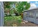 Backyard featuring a grassy lawn, screened-in porch, white fence, and a cute statue at 12316 Eldon Dr, Largo, FL 33774