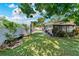 Backyard showing the lawn, patio area, garden bench, and exterior of the enclosed back porch at 12316 Eldon Dr, Largo, FL 33774