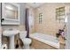 Bright bathroom with tub, pedestal sink and tile detail at 12316 Eldon Dr, Largo, FL 33774