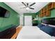 Comfortable bedroom features wood-style flooring, a ceiling fan and green walls at 12316 Eldon Dr, Largo, FL 33774