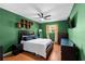 Cozy bedroom features wood-style flooring, a ceiling fan and green walls at 12316 Eldon Dr, Largo, FL 33774