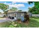 Cozy enclosed porch with ample windows, an adjacent patio, and small backyard shed, providing a relaxing outdoor space at 12316 Eldon Dr, Largo, FL 33774