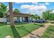 Inviting home with a lush front lawn, charming porch seating, and a neatly landscaped garden at 12316 Eldon Dr, Largo, FL 33774