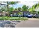 Charming single-story home featuring a well-manicured lawn, a blue front door, and ample parking on a sunny day at 12316 Eldon Dr, Largo, FL 33774