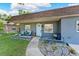 Charming home exterior with a light blue front door, garden bed, and seating area at 12316 Eldon Dr, Largo, FL 33774
