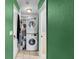 The laundry room features a stacked washer and dryer, tiled floor, and shelf storage at 12316 Eldon Dr, Largo, FL 33774