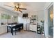 Bright sun room featuring a ceiling fan, dining area, and convenient storage shelves at 12316 Eldon Dr, Largo, FL 33774
