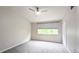 Bright carpeted bedroom with neutral walls, a ceiling fan, and one window allowing ample natural light at 1247 Kennewick Ct, Wesley Chapel, FL 33543
