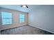 Bright carpeted bedroom with neutral walls, a ceiling fan, and two windows allowing ample natural light at 1247 Kennewick Ct, Wesley Chapel, FL 33543