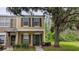 Inviting two-story townhome featuring a well-maintained lawn and black shutters on the windows at 1247 Kennewick Ct, Wesley Chapel, FL 33543