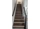 Stylish staircase features hardwood treads and black metal railings, adding a modern touch to the home's interior at 1247 Kennewick Ct, Wesley Chapel, FL 33543