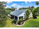 Aerial view showcases the expansive screened-in lanai, lush backyard, and meticulously landscaped property at 13321 Lewis Raulerson Rd, Dover, FL 33527