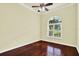 Bedroom with hardwood floors, fan, and large window providing natural light and a garden view at 13321 Lewis Raulerson Rd, Dover, FL 33527