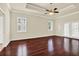 Bright bedroom featuring rich hardwood floors, tray ceiling, and access to the outdoors through glass doors at 13321 Lewis Raulerson Rd, Dover, FL 33527