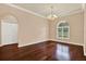 Cozy dining area with hardwood floors, arched window, and a charming chandelier at 13321 Lewis Raulerson Rd, Dover, FL 33527