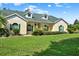 Charming home featuring a well-manicured lawn, green shutters, and lush landscaping at 13321 Lewis Raulerson Rd, Dover, FL 33527