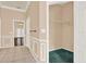 Neutral hallway with tile flooring, decorative trim, and doorway leading to a living area, with walk-in closet at 13321 Lewis Raulerson Rd, Dover, FL 33527