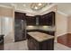Spacious kitchen with granite countertops, stainless steel appliances, dark cabinets, and large island at 13321 Lewis Raulerson Rd, Dover, FL 33527