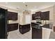 Gourmet kitchen with dark wood cabinets, granite countertops, stainless steel appliances, and center island at 13321 Lewis Raulerson Rd, Dover, FL 33527