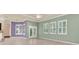 Open living room with tile flooring, multiple windows with shutters and light green accent walls at 13321 Lewis Raulerson Rd, Dover, FL 33527